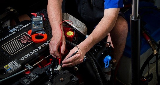 manos de un hombre arreglando un coche